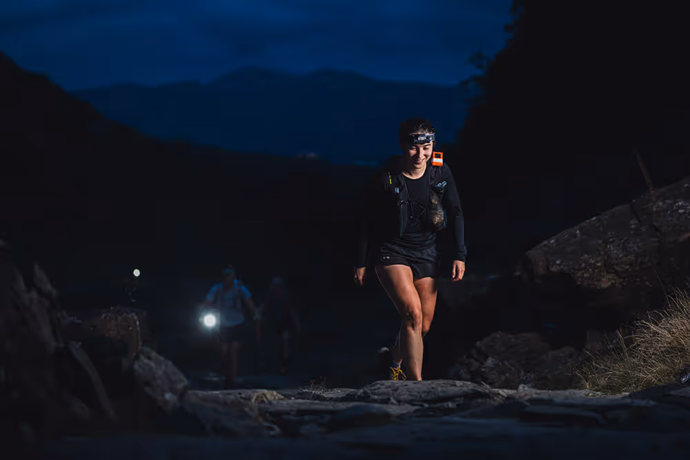 Long distances night image Image shows a lone female runner wearing a head torch in the dark